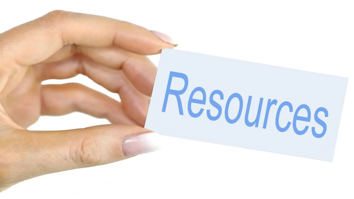 resources Resources written on a card held in a female left hand